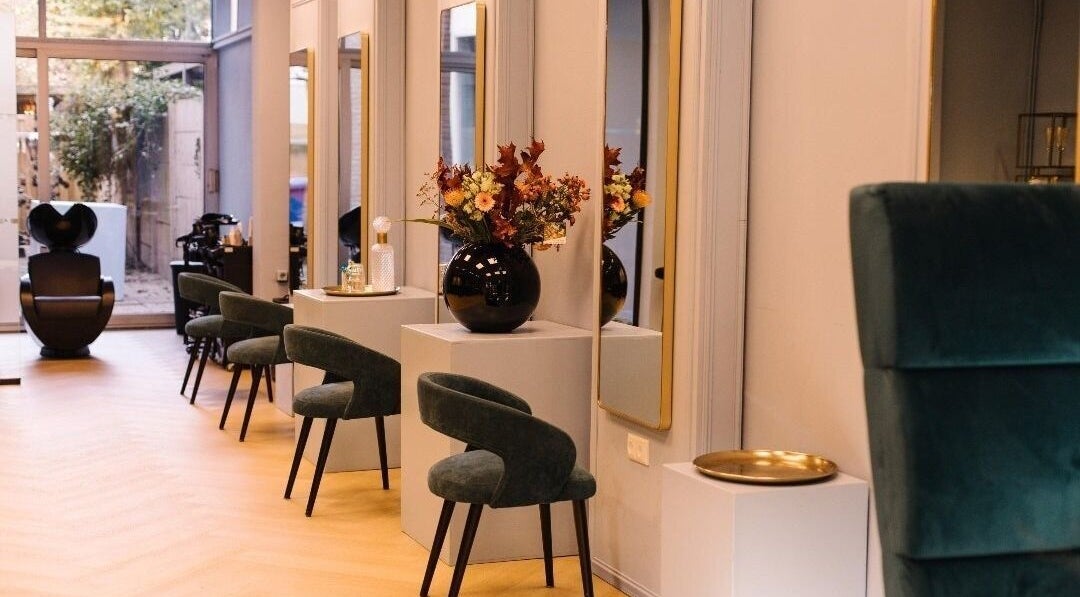 Moderne salon bij Ginzz in Den Haag, Zuid-Holland, NL met elegante stoelen en decoratieve planten.