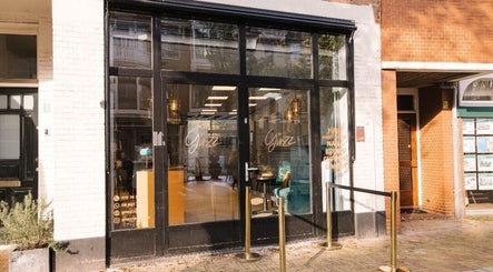 Vooraanzicht van Ginzz in Den Haag, Zuid-Holland, NL met stijlvolle glazen deuren.