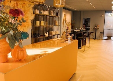 Sfeervol interieur van Ginzz, Den Haag, Zuid-holland, NL met bloemendecor op oranje balie.