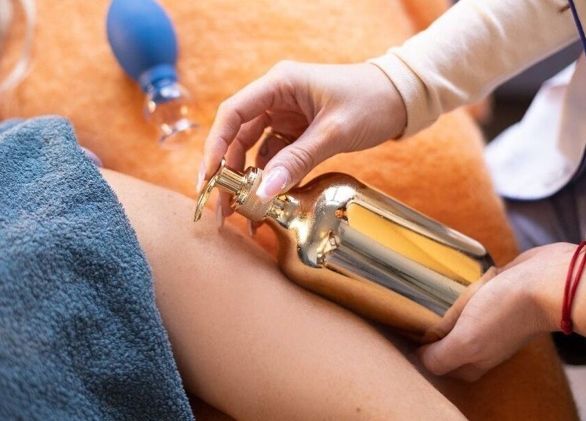 Therapeut gebruikt gouden fles tijdens massage bij Ginzz, Den Haag, Zuid-holland, NL.