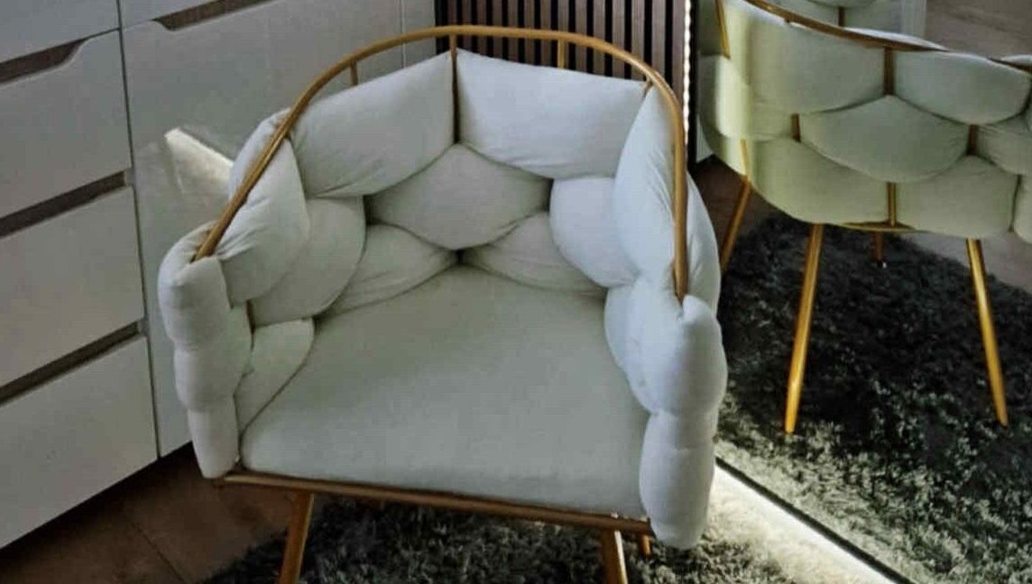 Elegant padded armchair at MODE, Thetford, England, GB, enhancing the cozy interior.