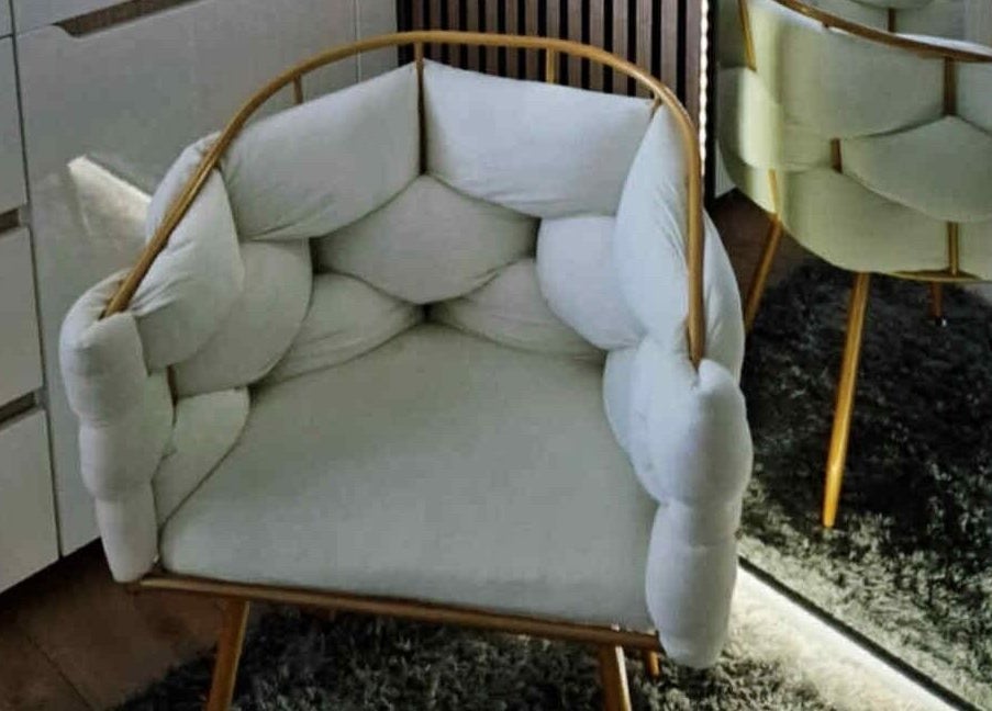 Elegant padded armchair at MODE, Thetford, England, GB, enhancing the cozy interior.