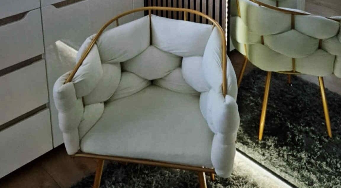 Elegant padded armchair at MODE, Thetford, England, GB, enhancing the cozy interior.