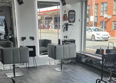 Modern salon interior at Divine Aesthetics & Beauty in Crewe, England, GB, showcasing sleek styling chairs and mirrors.