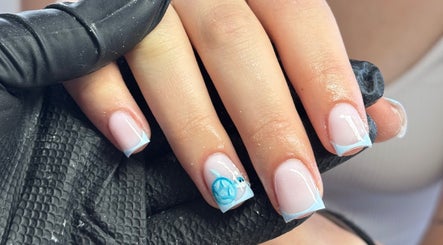 Blue French manicure at Nella Beauty, Oldbury, England, GB. Detailed nail art with flower design.