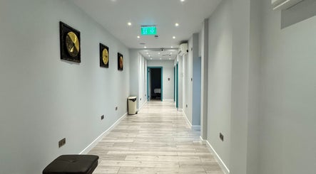 Bright hallway at Na Siam Spa, London, England, GB, featuring golden decor and wood flooring.