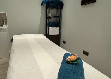 Relaxing massage room at Na Siam Spa, London, England, GB, featuring a cozy massage table and calming decor.