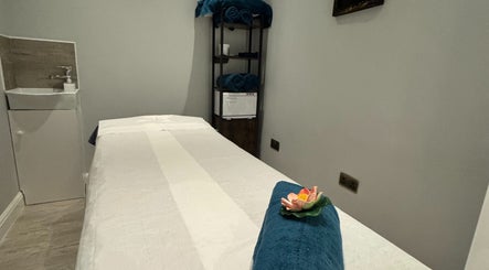 Relaxing massage room at Na Siam Spa, London, England, GB, featuring a cozy massage table and calming decor.