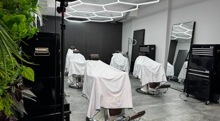 Modern barbershop interior at Barberesso, London, England, GB, featuring sleek barber chairs and bright lighting.