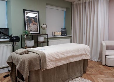 Relaxing spa treatment room at Bykiraquigley in Manchester, England, GB, featuring cozy decor and soft lighting.