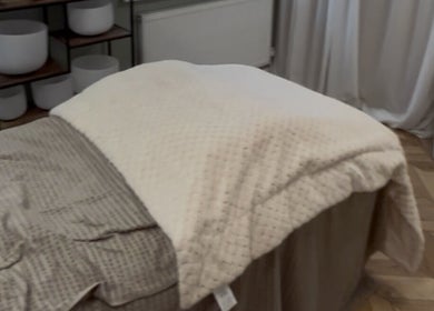 Cozy massage bed setup at Bykiraquigley, Manchester, England, GB, offering a serene relaxation space.