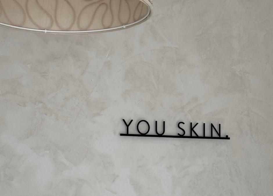 Mur minimaliste avec message 'You Skin' chez Joïa Piercings, Lyon, Auvergne-Rhône-Alpes, FR.