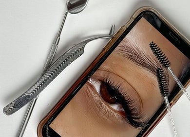 Close-up of eyelash tools and a phone showing lashes at Lashè, Amadora, Lisboa, PT.