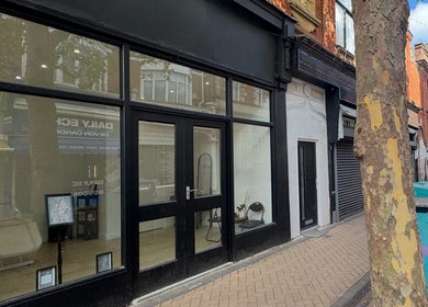 Street view of Dolls beauty lab in Bournemouth, England, GB. Glass-fronted exterior with modern decor.