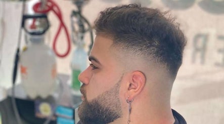 Client with a fresh fade haircut at RCutsBarberShop, Hamilton, Ontario, CA, showcasing expert grooming.