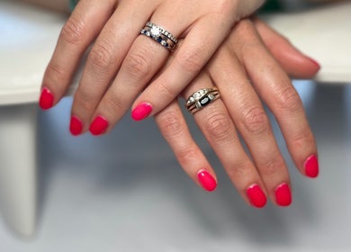 Vibrant pink manicure with rings at Nails at the Barn, Earls Colne, England, GB.