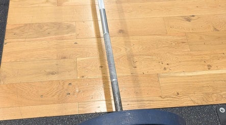 Powerlifting barbell on wooden floor at Burn With Jeff - Personal Training, Stretford, England, GB.