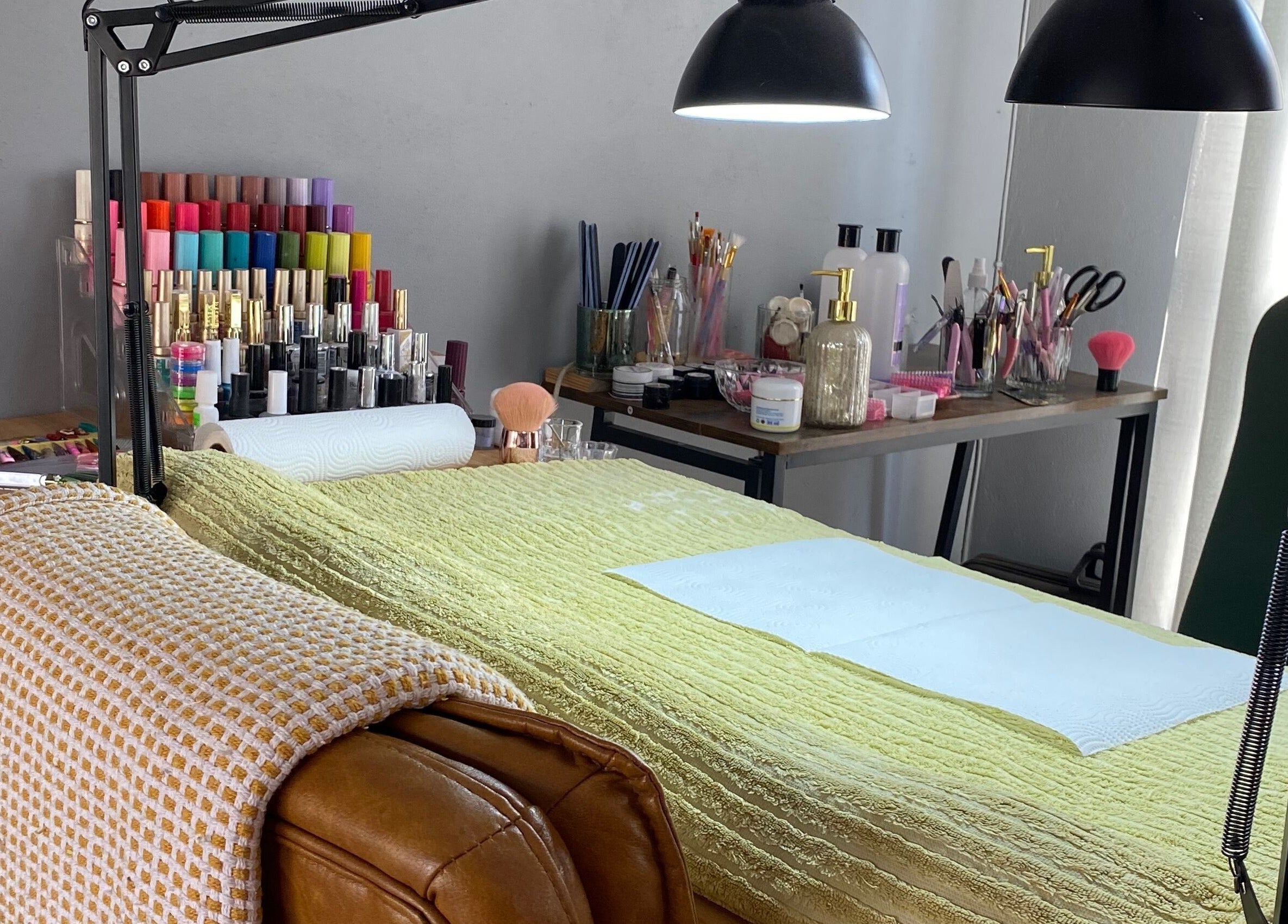 Bright, inviting nail station at Clawed._ in Akasia, Gauteng, ZA with colorful polishes and cozy chair.