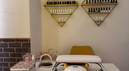 Estación de manicura en Aura Esthetics, Huelva, Andalucía, ES, con esmaltes y silla amarilla.