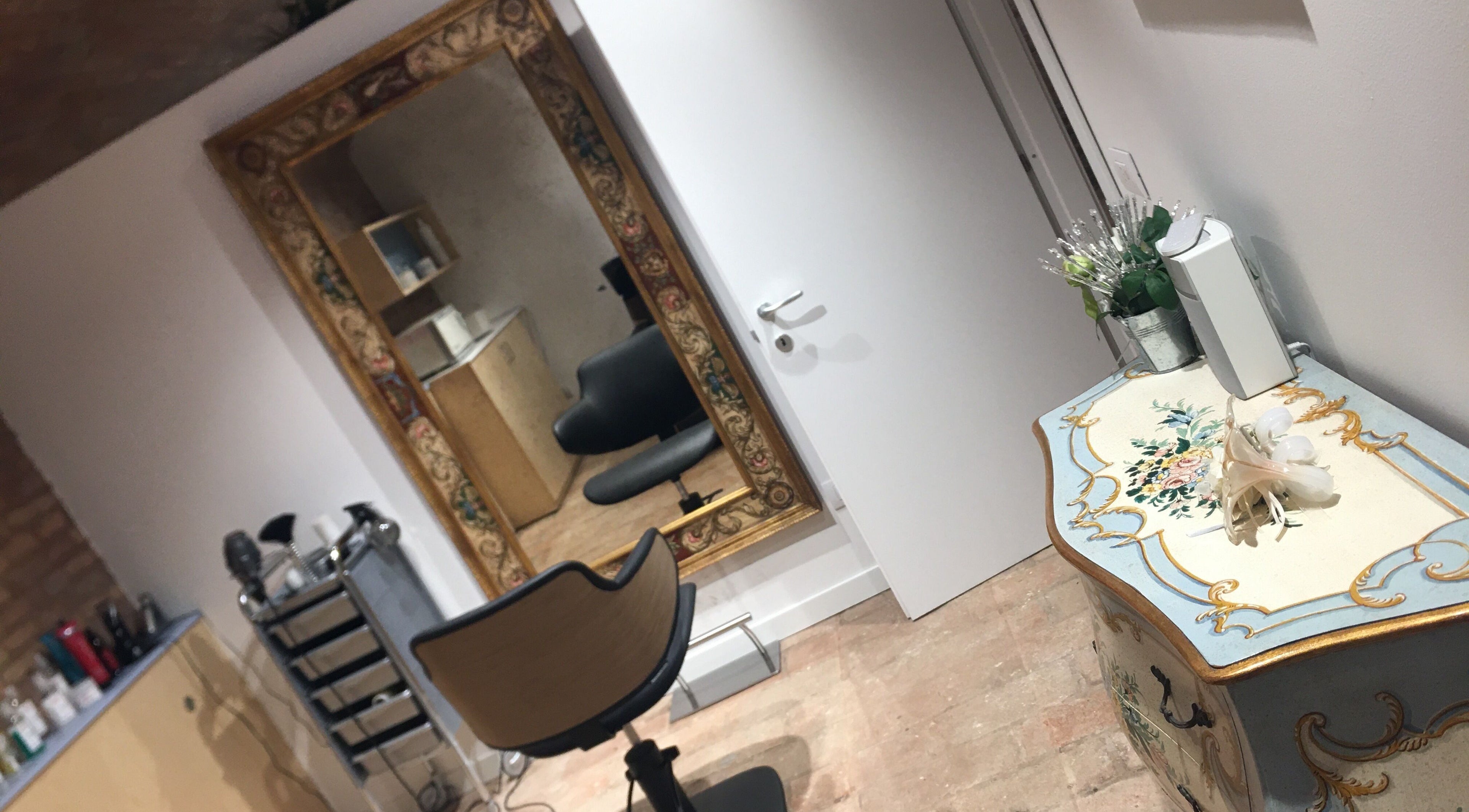 Interno di Glow Hair By Karina a Sassuolo, Emilia-romagna, IT con specchio ornato e mobile antico.