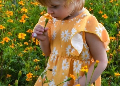 Kind geniet van bloemen in veld bij Visualex, Oosterzele, Vlaanderen, BE.