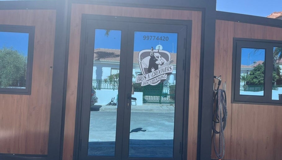 Entrance of Bros N' Groomers in Lemesos, Lemesos, CY showcasing modern glass doors.