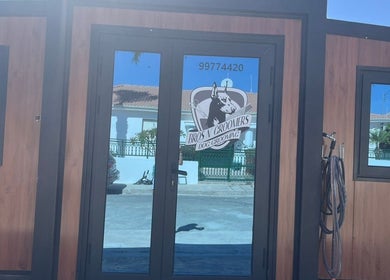 Entrance of Bros N' Groomers in Lemesos, Lemesos, CY showcasing modern glass doors.