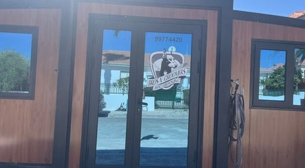 Entrance of Bros N' Groomers in Lemesos, Lemesos, CY showcasing modern glass doors.