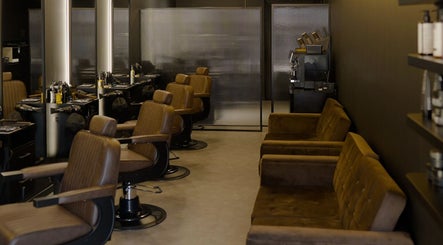 Elegant interior of Brocave Groomers in Dubai, Dubai, AE, featuring plush brown chairs and sleek styling stations.