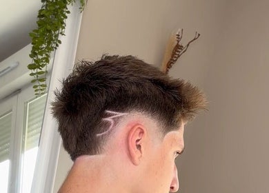 Coiffure moderne à Dryann Barber, Caen, Normandie, FR, présentant un design rasé unique sur le côté.