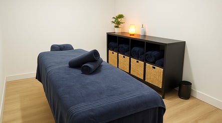Peaceful massage room at Vital Restore in London, England, GB, featuring a soothing setup with neatly arranged towels.