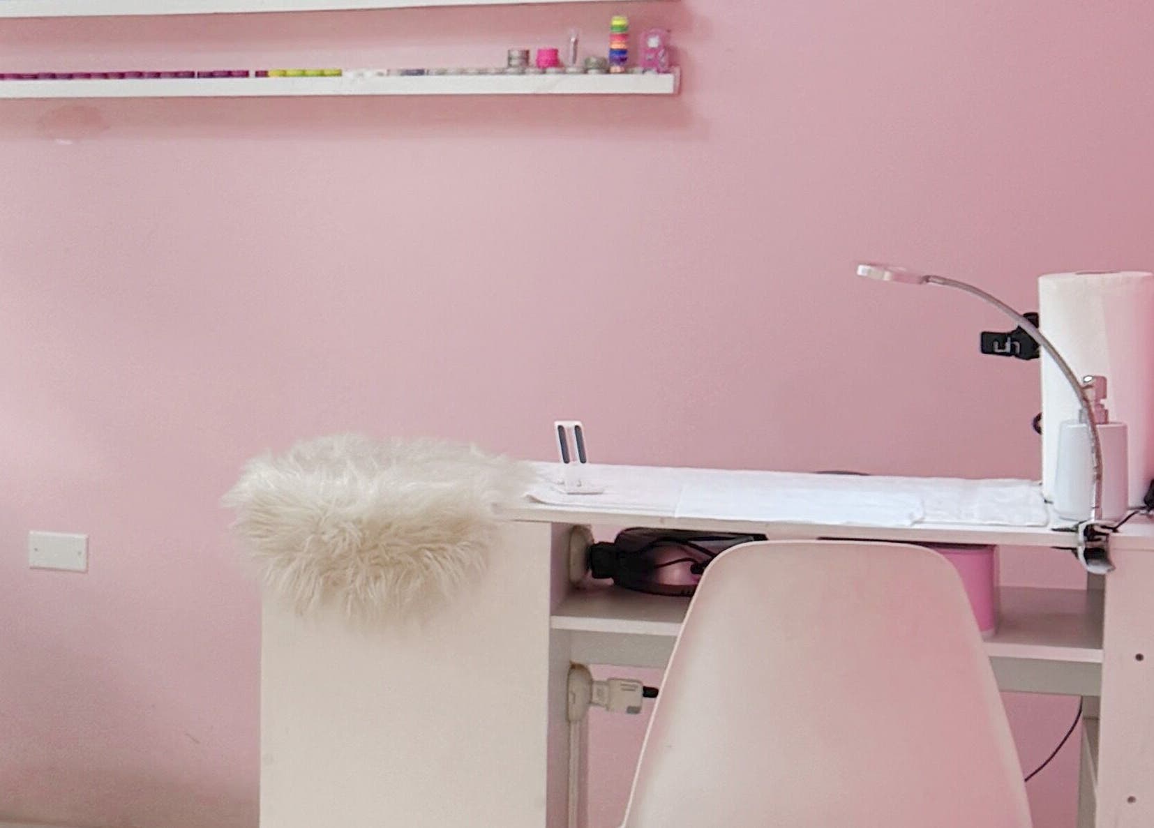 Estación de manicura en TRUST, Quetzaltenango, Quetzaltenango, GT con decoración rosa y muebles acogedores.