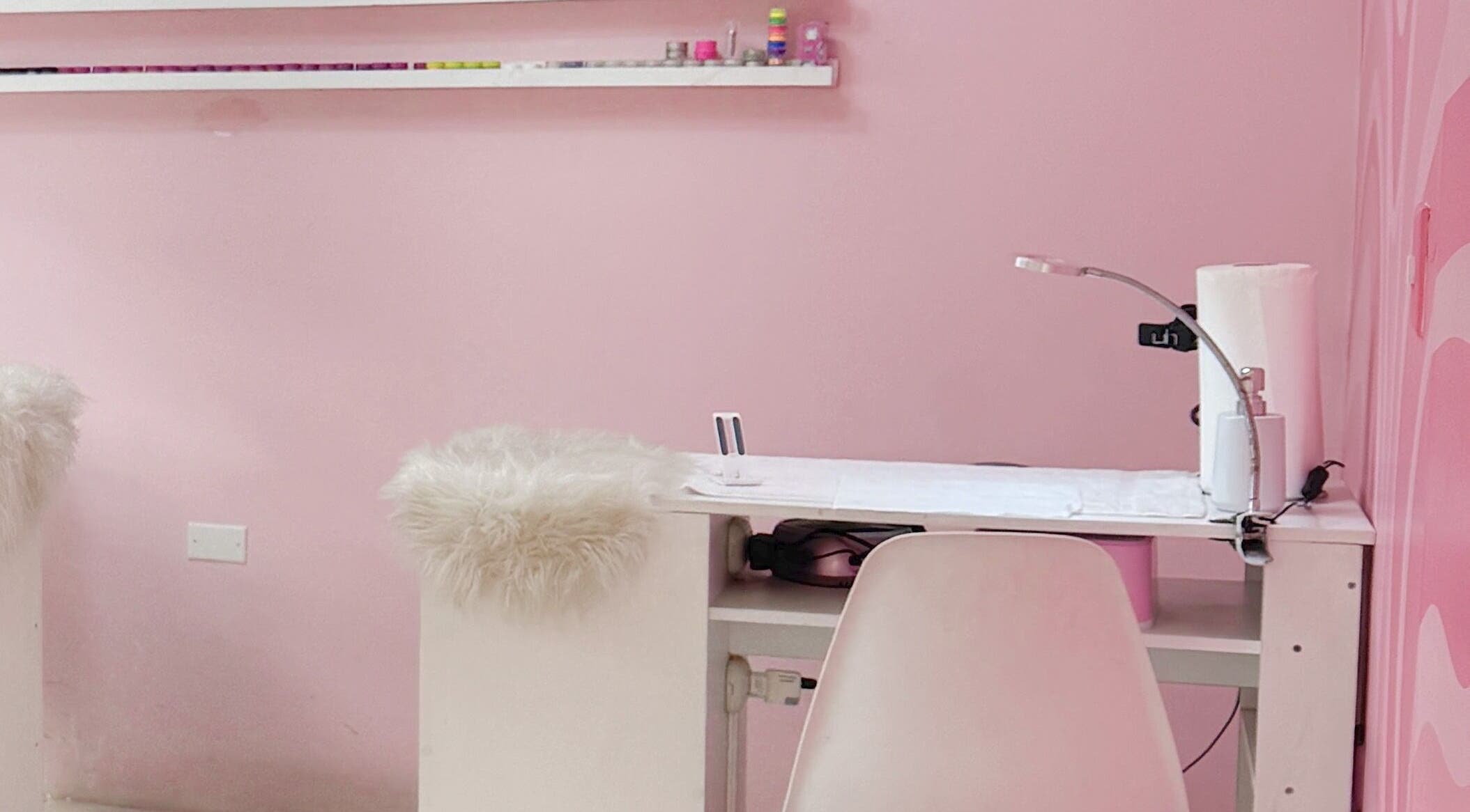 Estación de manicura en TRUST, Quetzaltenango, Quetzaltenango, GT con decoración rosa y muebles acogedores.