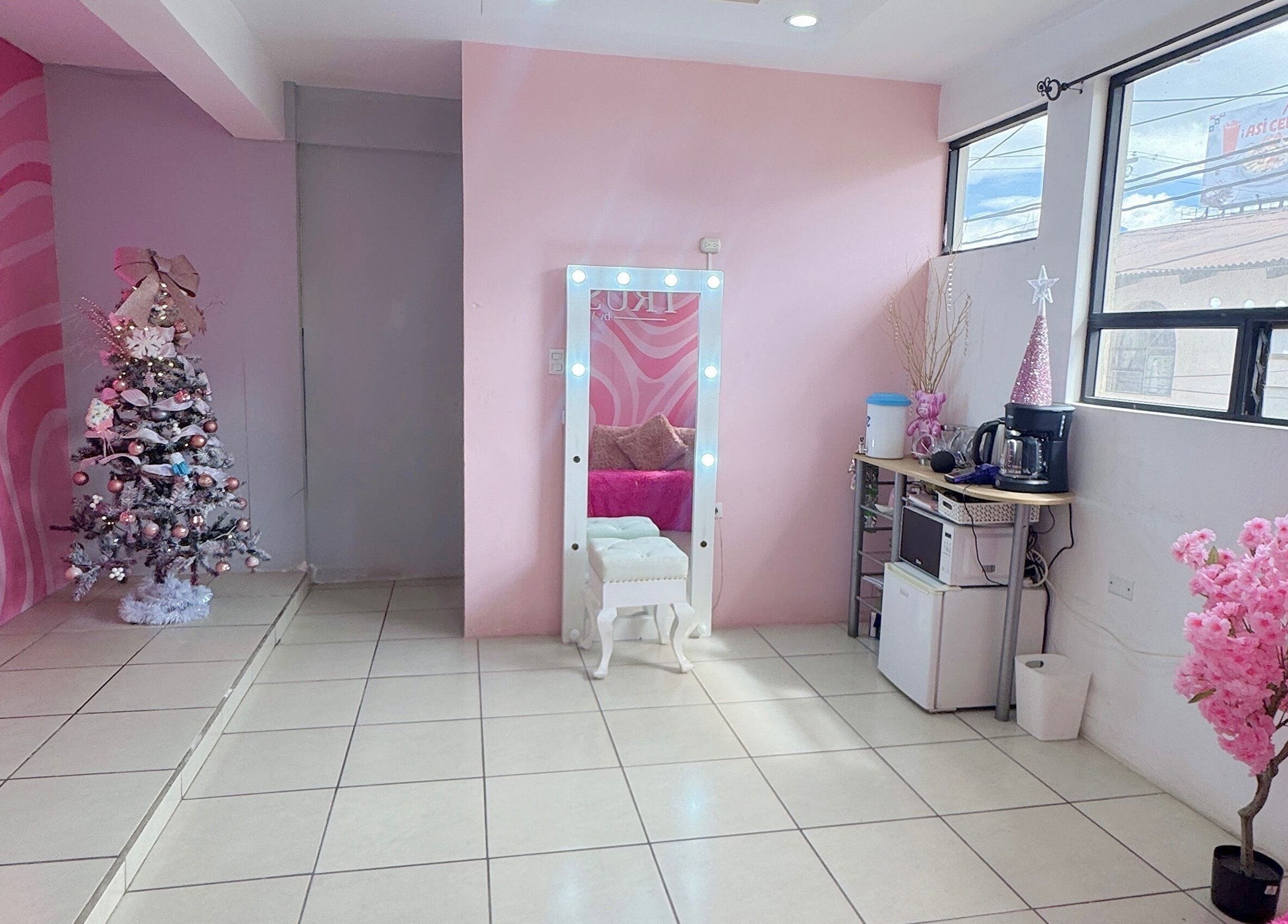 Espacio elegante en TRUST, Quetzaltenango, con decoración rosa y espejo iluminado.