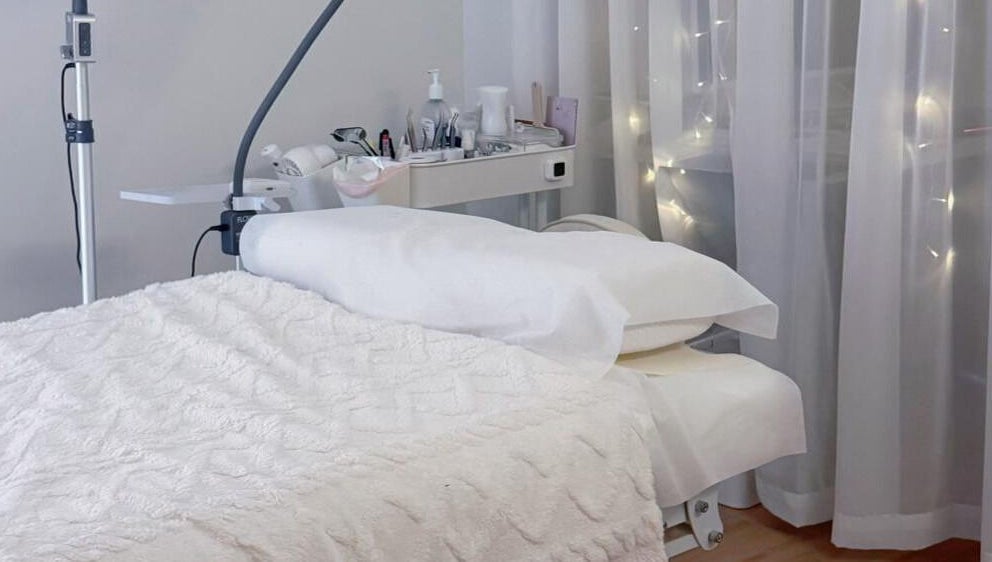 Luxurious spa bed setup at Jusjollie, Singapore with delicate fairy lights and plush linens.