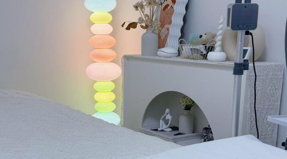 Tranquil treatment room at Jusjollie, Singapore, SG, with soft lighting and modern decor.