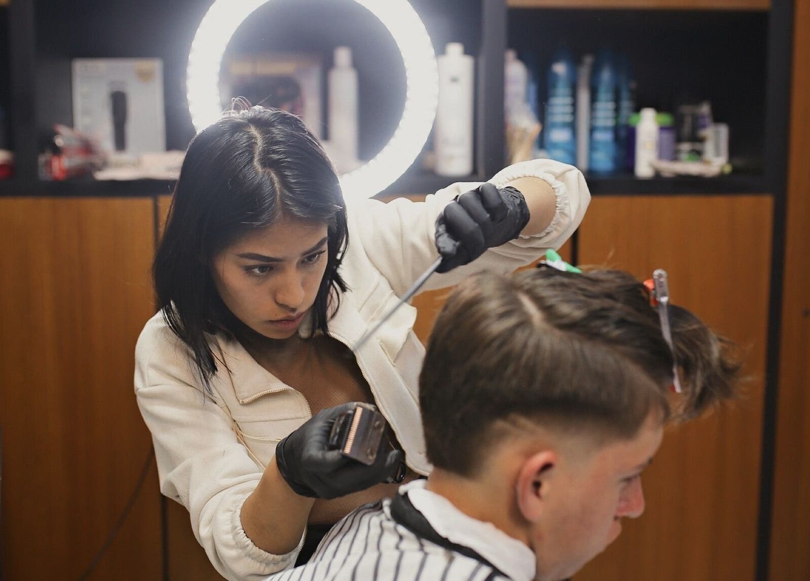 Estilista profesional haciendo un corte en D'Avila Barberia, Cuenca, Azuay, EC.