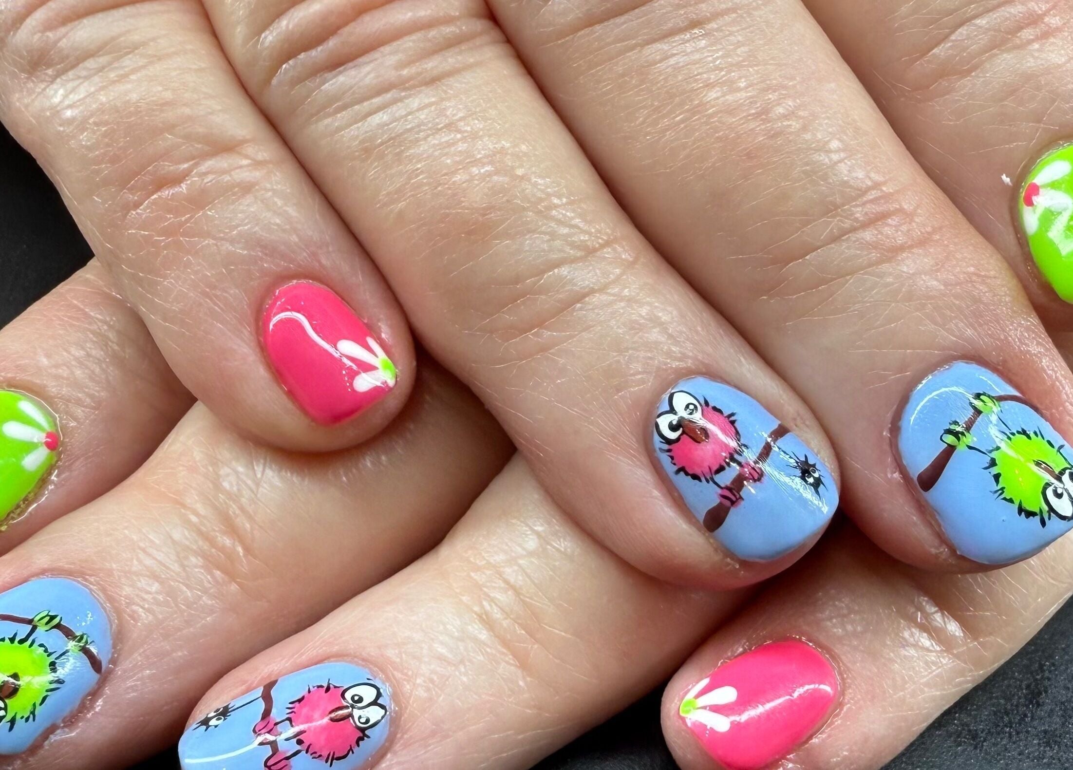 Colorful owl nail art at Glam By Leigh, Washington, Utah, US. Features vibrant pink and green designs.