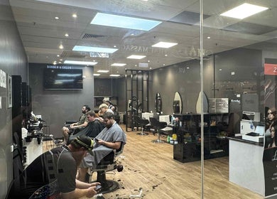 Inside view of Captain Barber Oasis in Palmerston City with clients receiving haircuts.