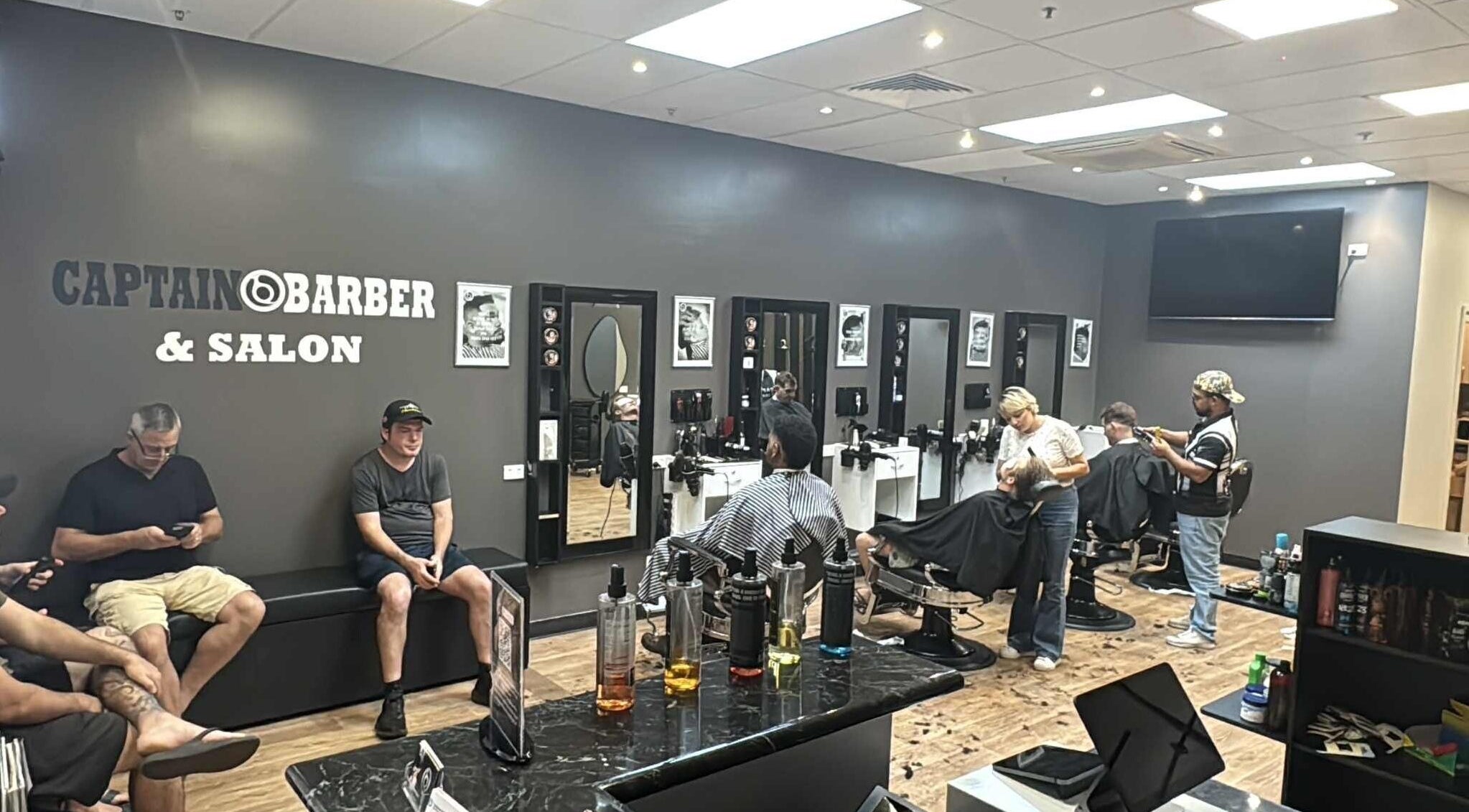 Inside Captain Barber Oasis at Palmerston City, NT, AU, showcasing stylish haircuts and modern interior.