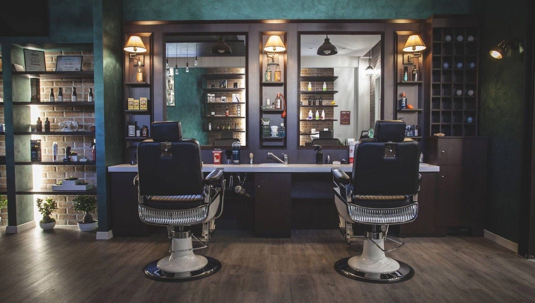 Interno di lusso di From Zero Barberia Lucana a Matera, Basilicata, IT con poltrone e mensole illuminate.