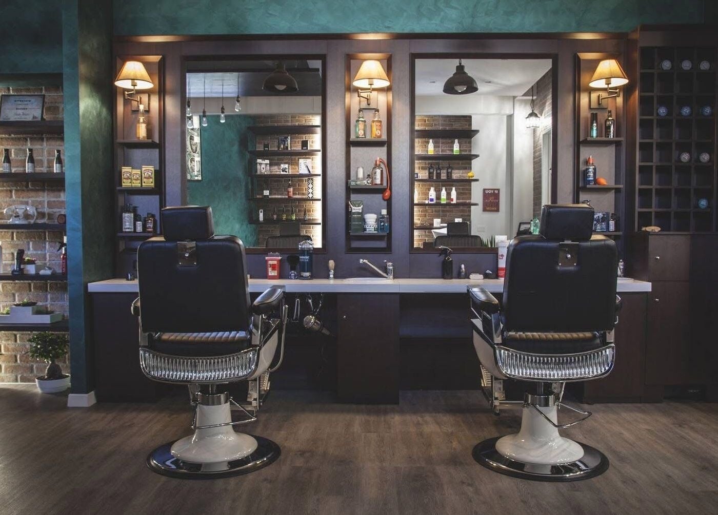 Interno di lusso di From Zero Barberia Lucana a Matera, Basilicata, IT con poltrone e mensole illuminate.