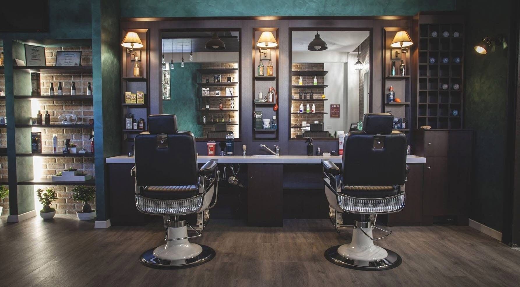 Interno di lusso di From Zero Barberia Lucana a Matera, Basilicata, IT con poltrone e mensole illuminate.