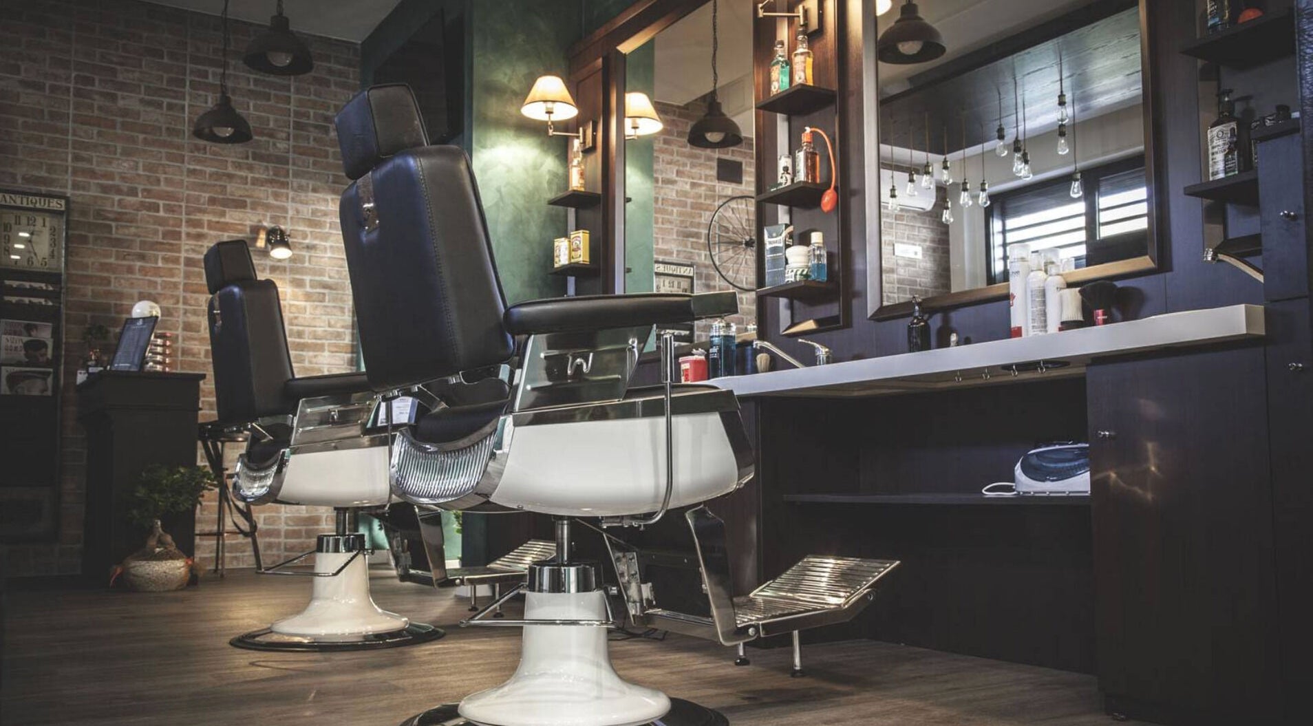 Elegante interno di From Zero Barberia Lucana a Matera, Basilicata, IT, con poltrone da barbiere in pelle.