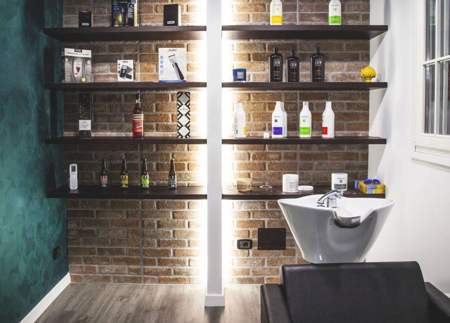 Scaffali prodotti e lavandino moderno presso From Zero Barberia Lucana, Matera, Basilicata, IT.