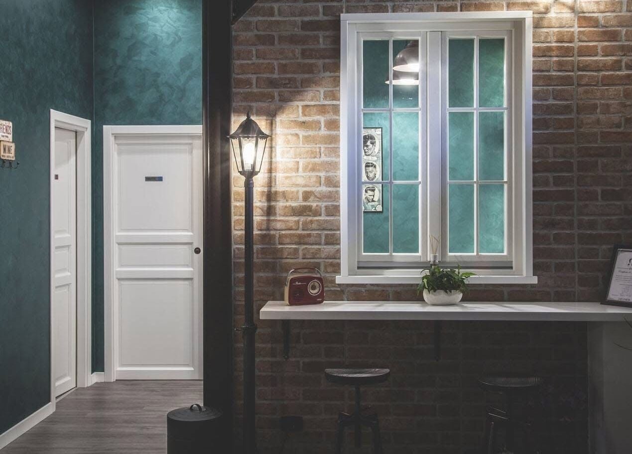 Interni vintage di From Zero Barberia Lucana a Matera, Basilicata, IT con mattoni a vista e illuminazione calda.