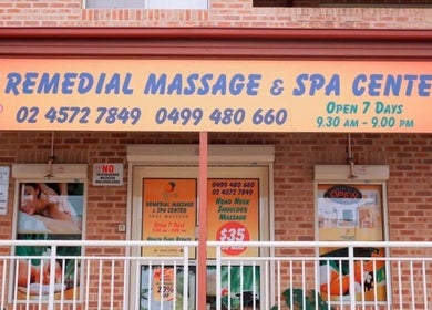 Entrance of Remedial Massage & Spa Centre, North Richmond, New South Wales, AU with vibrant sign and glass doors.