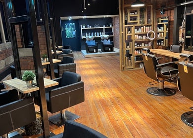 Modern salon interior at Hidden Nail Works, Middlestown, England, GB, featuring stylish barber chairs and product shelves.