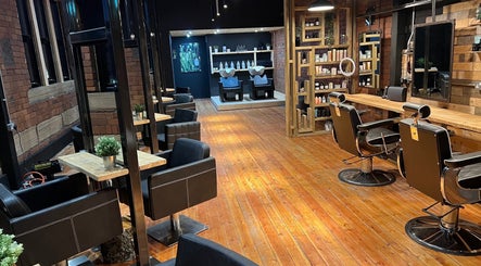 Modern salon interior at Hidden Nail Works, Middlestown, England, GB, featuring stylish barber chairs and product shelves.