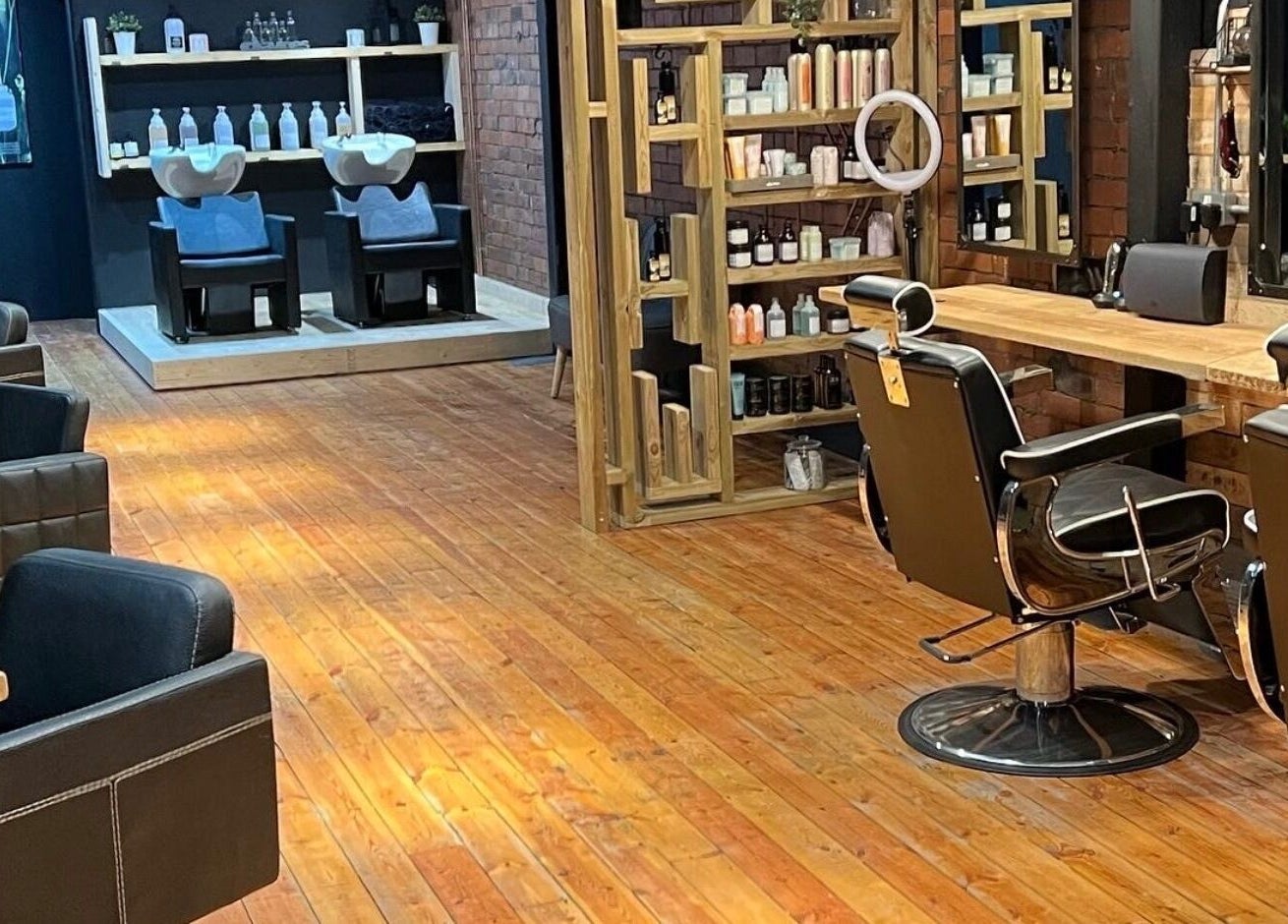 Inside Hidden Nail Works salon, Middlestown, England. Stylish chairs, wooden floors, modern decor.
